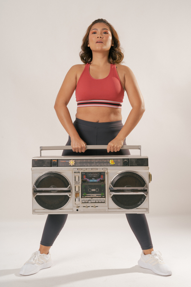 Woman in Activewear with Vintage Radio on White Background